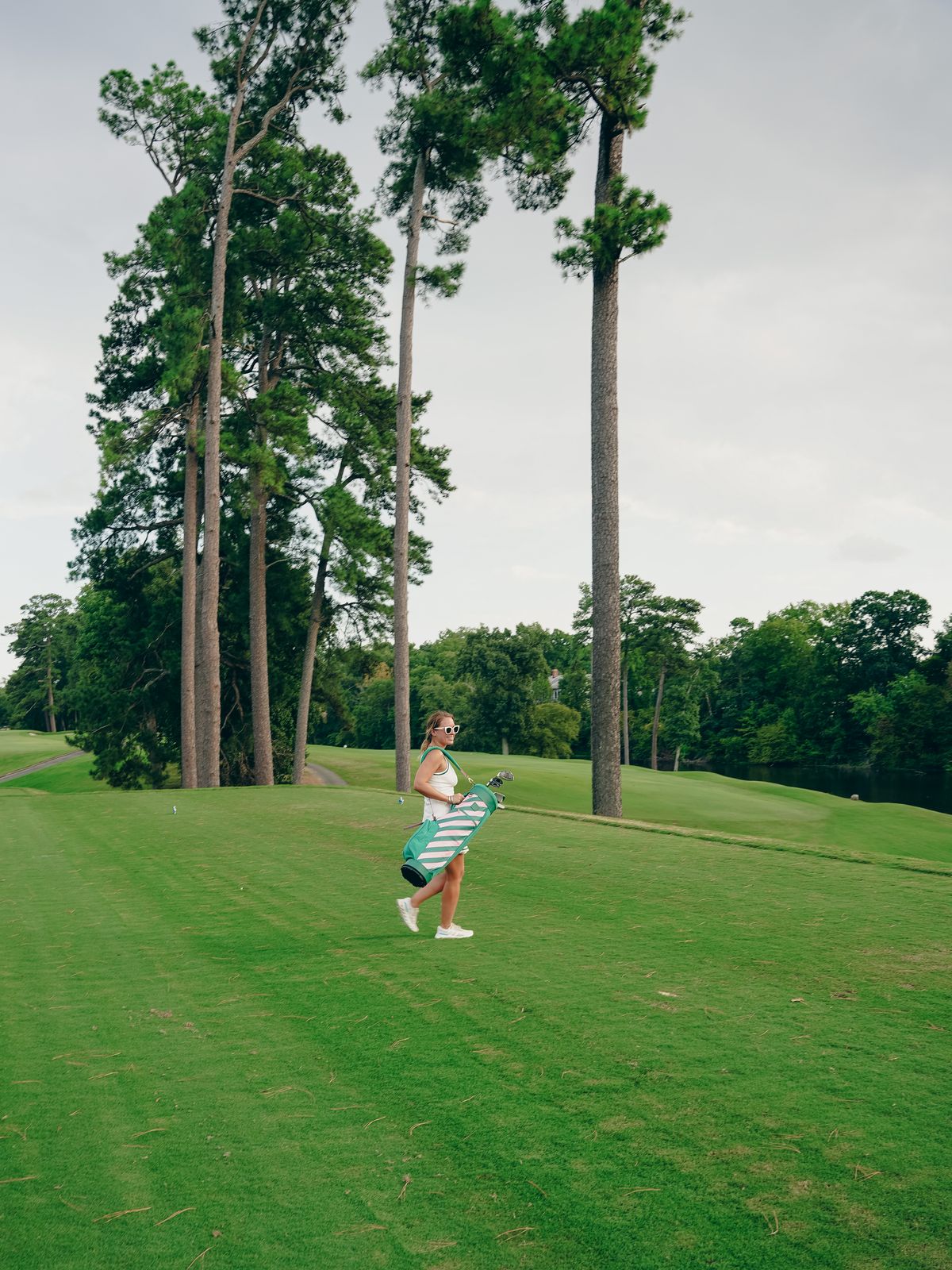 Danielle carrying the Gemma bag down the fairway under the pines